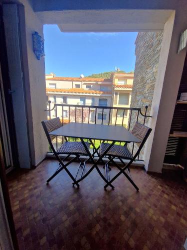 une table et deux chaises sur un balcon dans l'établissement La Bourboule, à Collioure