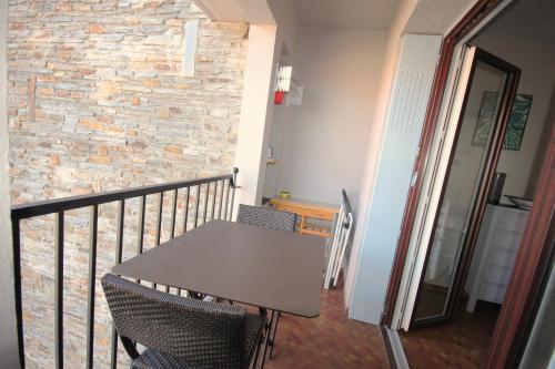 d'une table et de chaises sur un balcon avec un mur en pierre. dans l'établissement La Bourboule, à Collioure