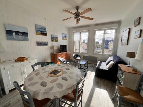 un salon avec une table et un canapé dans l'établissement Sur les toits de St Aubin - La Mer, à Saint-Aubin-sur-Mer