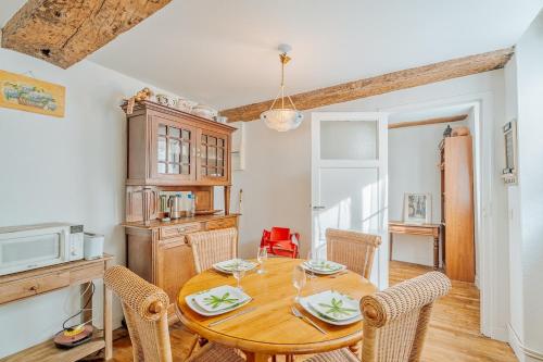 une salle à manger avec une table et des chaises en bois dans l'établissement Porte des Bès T2 dans Intra-muros plage à 10 m, à Saint-Malo