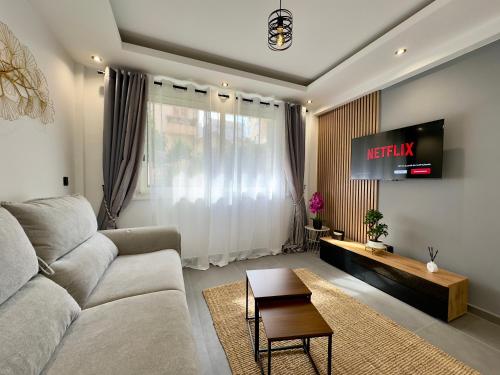 un salon avec un canapé et une télévision dans l'établissement Cannes Évasion by SCLS Locations, à Cannes