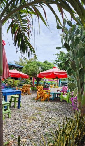 a group of tables and chairs with red umbrellas at Dunas Tatacoa in Villavieja