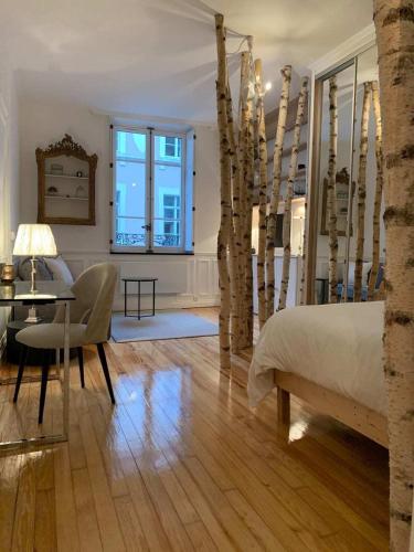 une chambre avec un lit, une table et des chaises dans l'établissement La Suite Carmen - Hypercentre de Reims, à Reims