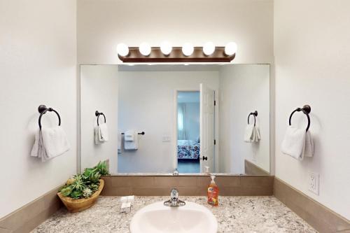 a bathroom with a sink and a large mirror at Lighthouse By The Cove in Seaside