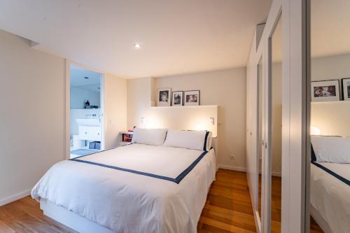 een slaapkamer met een groot wit bed en een raam bij Nomads Lux - 3BDR Foz Velha Porto in Porto