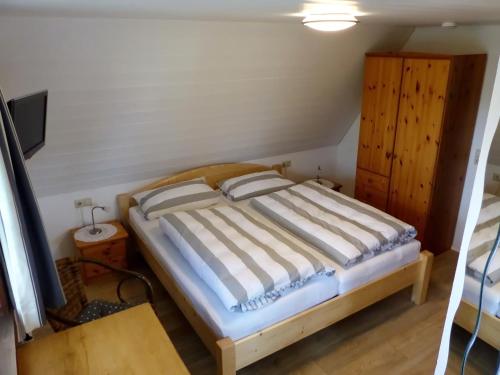 a bedroom with a bed and a wooden cabinet at Haus Am Tannenhain in Titisee-Neustadt