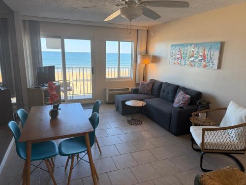 a living room with a couch and a table and chairs at Oceanfront condo, ocean view and indoor pool in Virginia Beach
