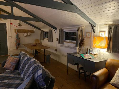 a living room with a couch and a desk at The Den at Husthwaite Gate in Husthwaite