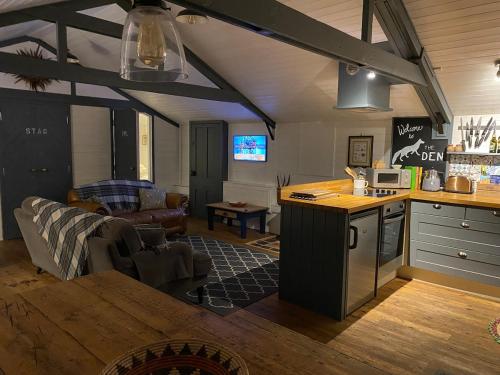a kitchen and living room with a couch and a table at The Den at Husthwaite Gate in Husthwaite