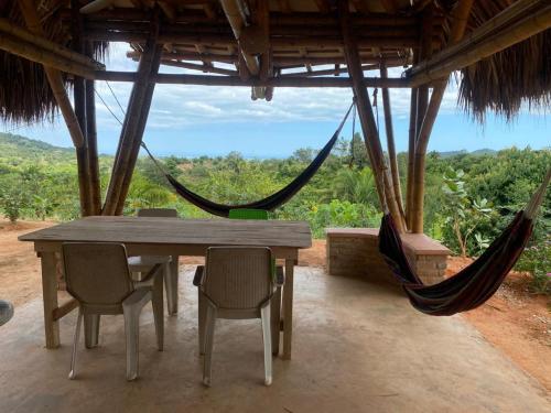- une table et des chaises dans une pièce avec hamac dans l'établissement Casa Akasha, à Mingueo