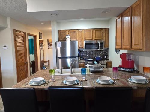a kitchen with a table with plates and glasses on it at Swan's Woodland Getaway Condo in Reeds Spring