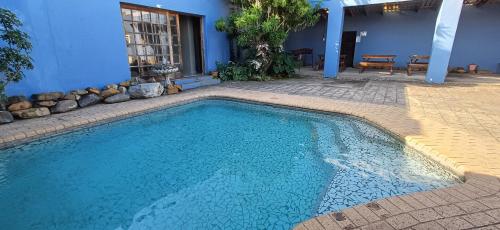 a swimming pool in front of a blue house at Oceanic Flashpackers accommodation in East London