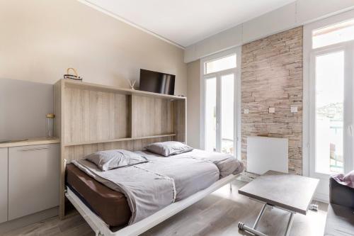 une chambre avec un lit et un mur de briques dans l'établissement Studio Toulouse centre Matabiau, à Toulouse