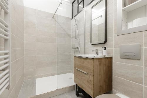une salle de bain avec un lavabo, une baignoire et un miroir dans l'établissement Studio Toulouse centre Matabiau, à Toulouse