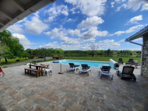 un patio avec des chaises et une piscine dans l'établissement Villa de Campagne au bord de l'Adour, à Saint-Laurent-de-Gosse