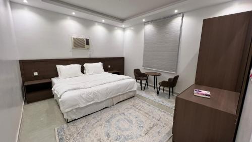 a bedroom with a bed and a table and chairs at مسكن ركاز المدن in Medina