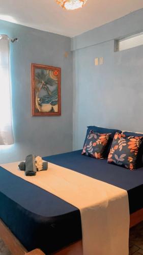 a bed in a room with a blue wall at Suites Estrela Dalva in Lauro de Freitas