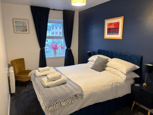 a bedroom with a bed with white sheets and a window at 16 Macgregor court, Oban in Oban