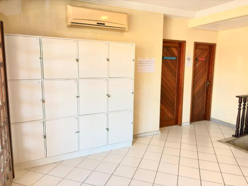 a room with white cabinets and a door at Terra do Sol Pousada e Hostel in Porto Seguro
