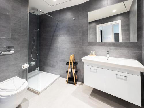 a bathroom with a toilet sink and a mirror at Luxury Little Gem Mercury Tower w Rooftop Pool By Arco Collection in St. Julianʼs