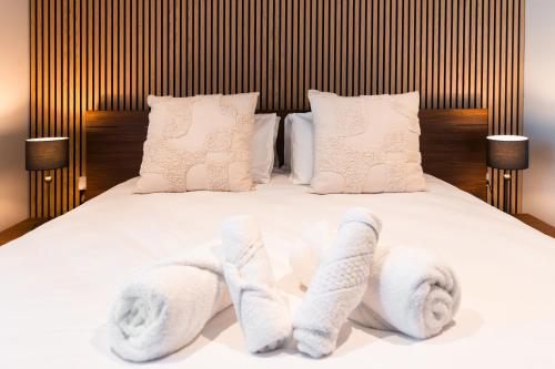 a bed with two pairs of towels on it at Luxury Little Gem Mercury Tower w Rooftop Pool By Arco Collection in St. Julianʼs