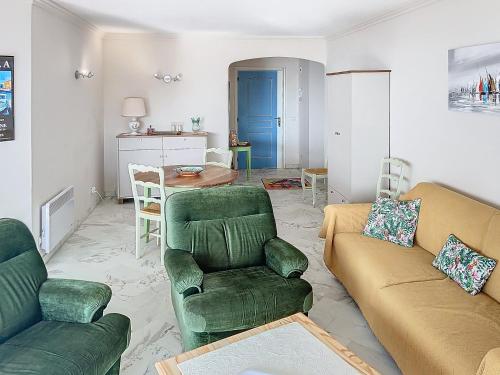 - un salon avec deux chaises vertes et une table dans l'établissement A 2 pas des plages du Midi 300L, à Cannes