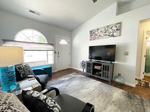 ein Wohnzimmer mit Couch und Fernseher in der Unterkunft Peaceful Downtown Kanab Family Townhome Dew Drop Inn in Kanab