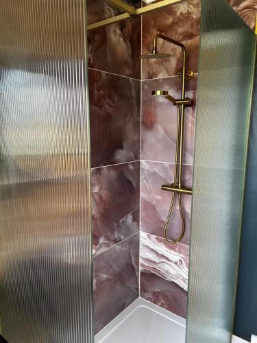 a bathroom with a shower with a marble wall at Atlantic View - Sauna and Sunsets in Isle of Lewis