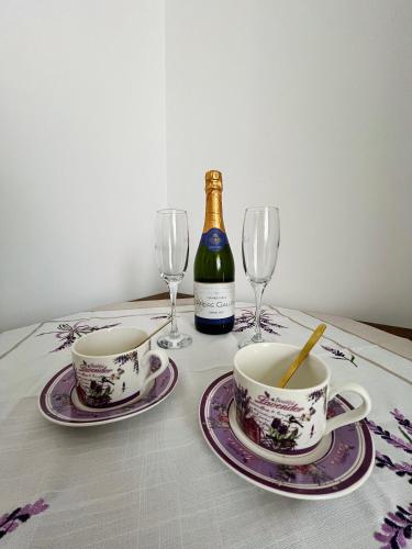 a table with two cups and a bottle of wine at The Salin Spot in Turda