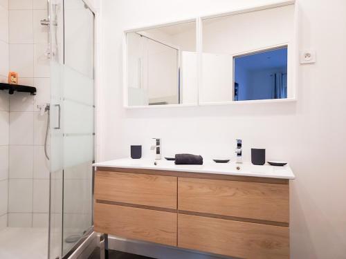 une salle de bain avec un lavabo et un miroir dans l'établissement Maison en plein Cœur de Deauville, tout à pied, 6 personnes, à Deauville