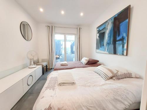 - une chambre blanche avec 2 lits et un miroir dans l'établissement Maison en plein Cœur de Deauville, tout à pied, 6 personnes, à Deauville