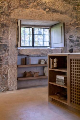 a room with a book shelf and a window at Terra Rosa Country House & Vineyards in Ponte de Lima