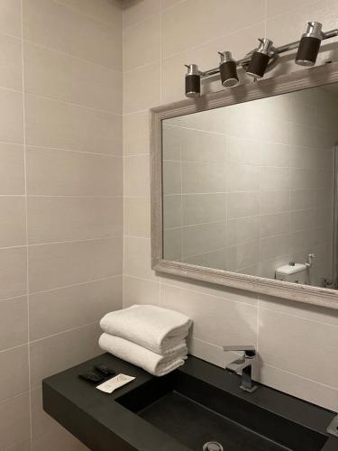 a bathroom with a sink and a mirror and towels at Villa Tower Inn in Pisa