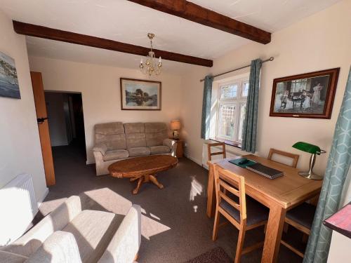 a living room with a couch and a table at Hunston Mill Self Catering Dog Stay For Free in Chichester