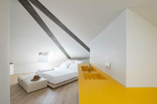 a bedroom with a bed and a yellow table at A'Mar by Alojamento Ideal in Póvoa de Varzim