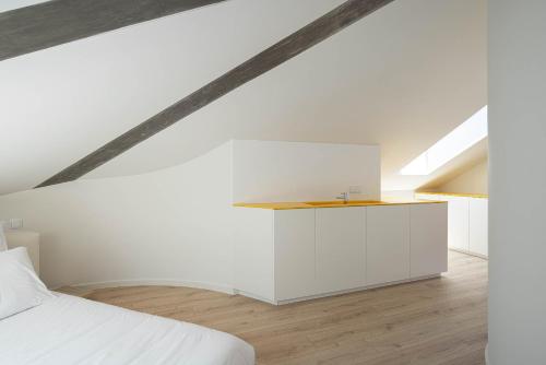 a bedroom with a white bed and a white cabinet at A'Mar by Alojamento Ideal in Póvoa de Varzim