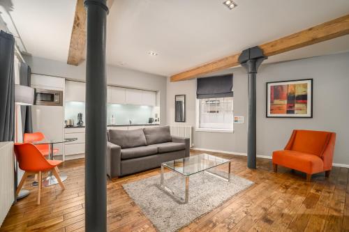 a living room with a couch and a table and chairs at Destiny Scotland -The Malt House Apartments in Edinburgh