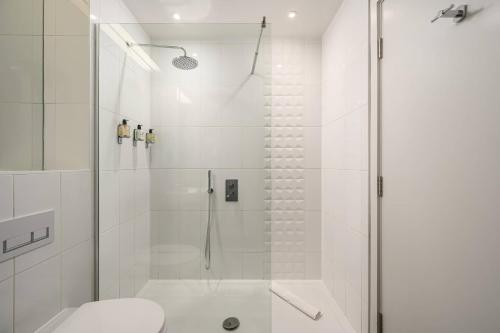 a white bathroom with a shower and a toilet at Destiny Scotland -The Malt House Apartments in Edinburgh
