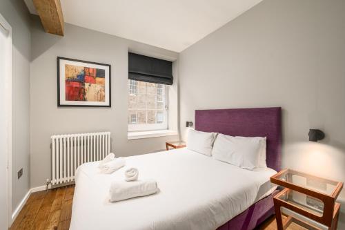a bedroom with a large bed with towels on it at Destiny Scotland -The Malt House Apartments in Edinburgh