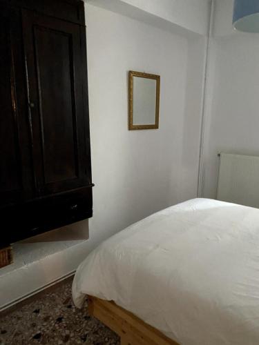 a bedroom with a bed and a wooden cabinet at House with marina view in Plomarion