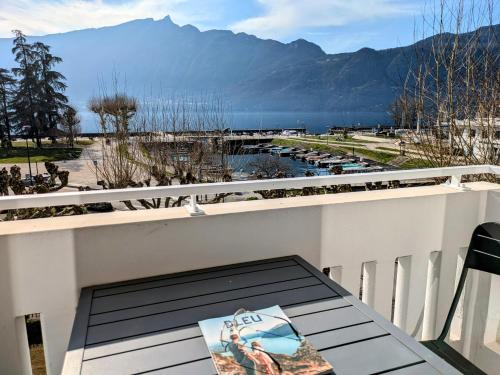- une table sur un balcon avec vue sur le port de plaisance dans l'établissement LA VILLA DU PETIT PORT - Appartements & chambres, à Aix-les-Bains