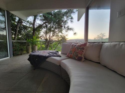 a white couch with pillows sitting on a patio at Naturaleza, Flora y Fauna in Los Altos de Cerro Azul