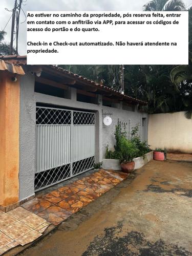 a house with a white gate and a driveway at CIG Hostel in Goiânia