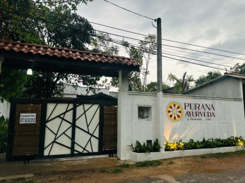 a building with a sign on the side of it at Nivartana Villa and Purana Ayurveda Center in Bentota