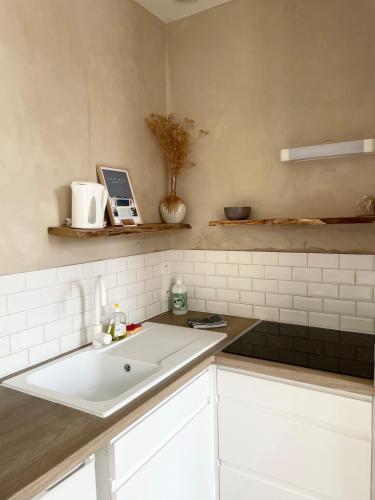 - une cuisine avec un évier blanc et un comptoir dans l'établissement Studio centre ville proche plages et commerces, à Saint-Malo