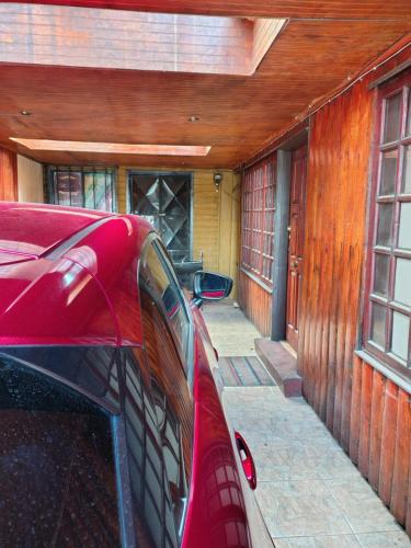 a red car parked in front of a house at Guillermo Marconi in Los Ángeles
