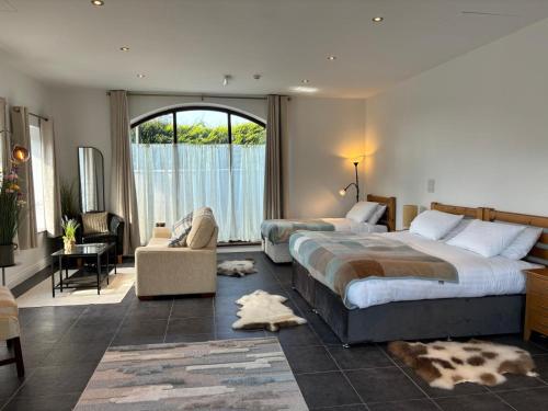 a hotel room with two beds and a window at TheJewel Lodge & Spa Glengarriff in Glengarriff