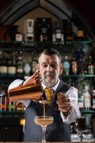 a man in a bar making a drink at The Lodges at Kilkea Castle in Kilkea