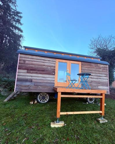 une petite maison avec une table et deux chaises dans l'établissement Boubínská maringotka, à Drslavice