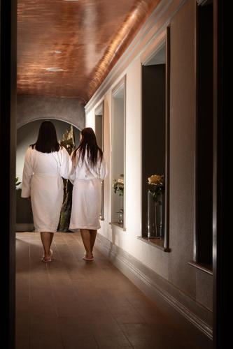 two women in white dresses looking into a mirror at The Lodges at Kilkea Castle in Kilkea
